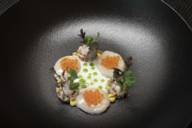 Ein Gericht mit Kaviar auf einem schwarzen Teller im Restaurant Atelier in München