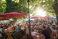 Der Biergarten am Viktualienmarkt gefüllt mit Gästen an einem sonnigen Tag in München.