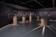 Blick in einen Austellungsraum der Archäologischen Staatssammlung mit Vitrinen und Zeittafel an den Wänden.